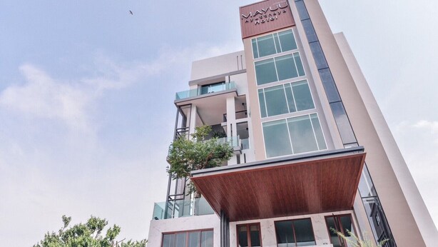 Un moderno edificio de hotel con un cartel llamativo que dice "MAYUU Ayutthaya Hotel".