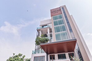 Un moderno edificio de hotel con un cartel llamativo que dice "MAYUU Ayutthaya Hotel".
