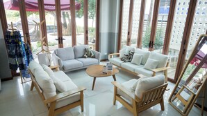 Un moderno vestíbulo de hotel con un área de estar que incluye sofás y sillones, una mesita de centro y vistas a través de amplias ventanas.
