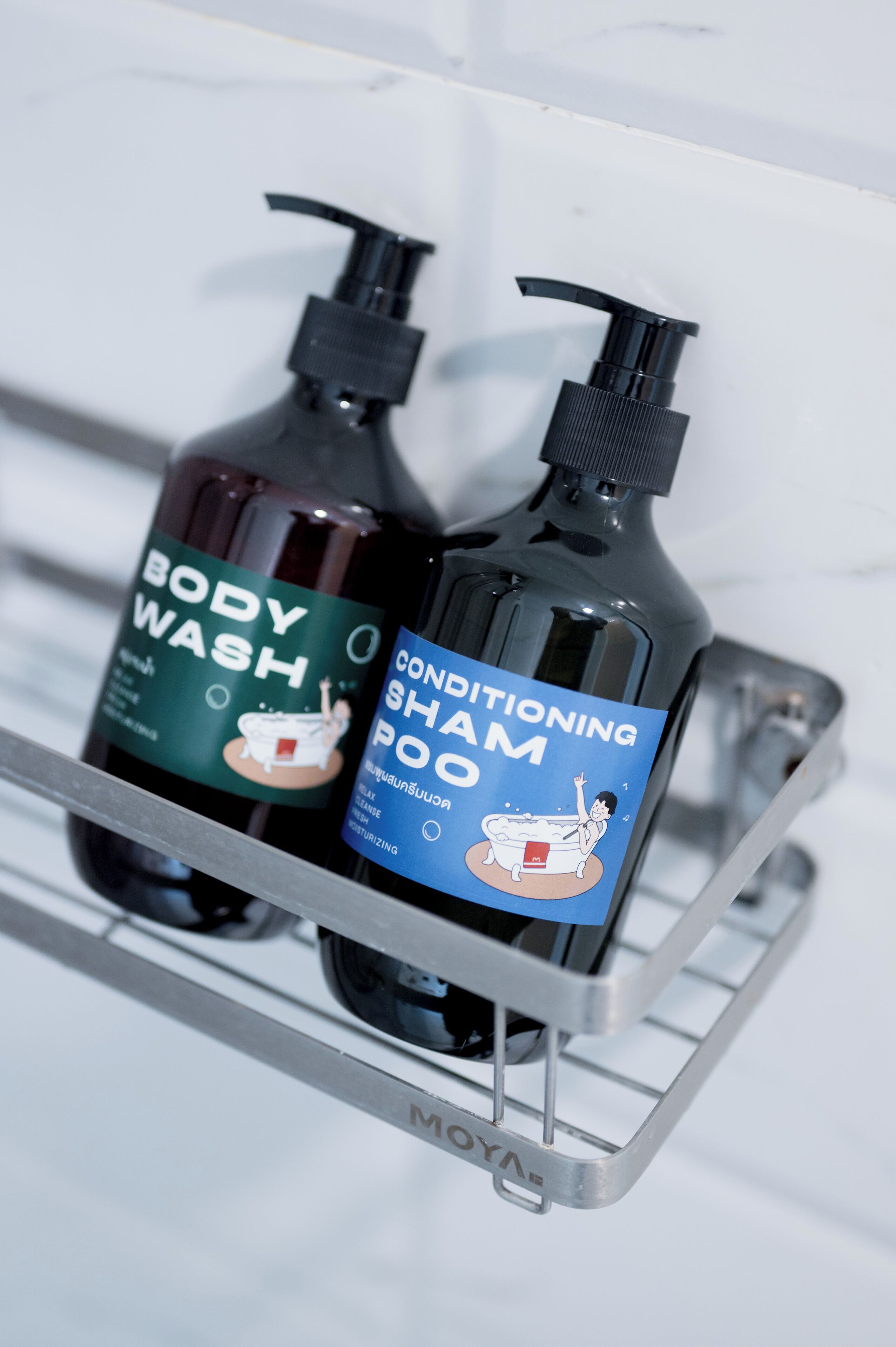 Two bottles of body wash and conditioning shampoo on a metal shelf.