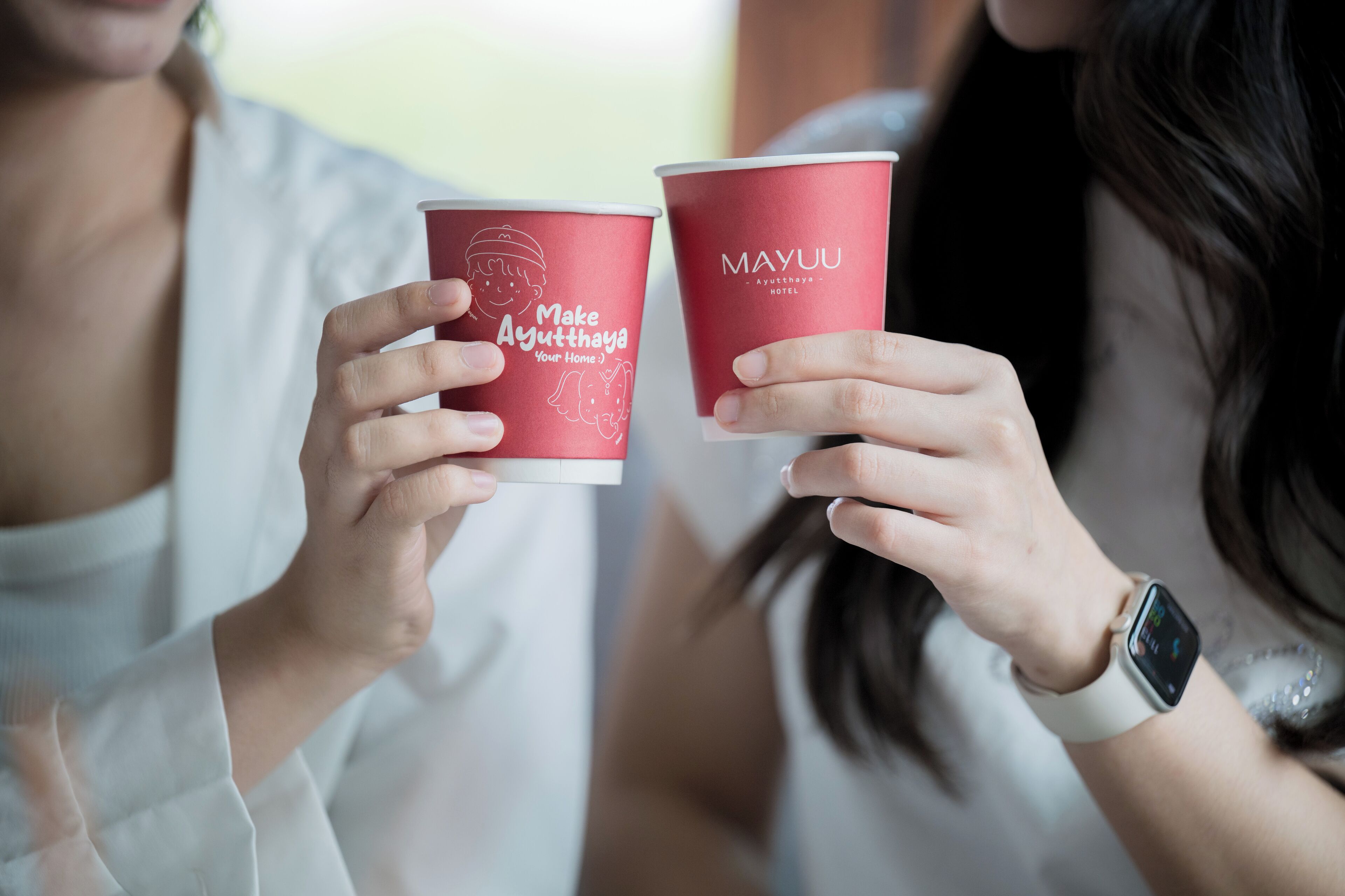 Dos personas sosteniendo vasos rojos con texto.