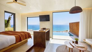 A modern bedroom with a bed, desk, and a view of the ocean. - KOIA All - Suite Well Being Resort - Adults Only (Kos)