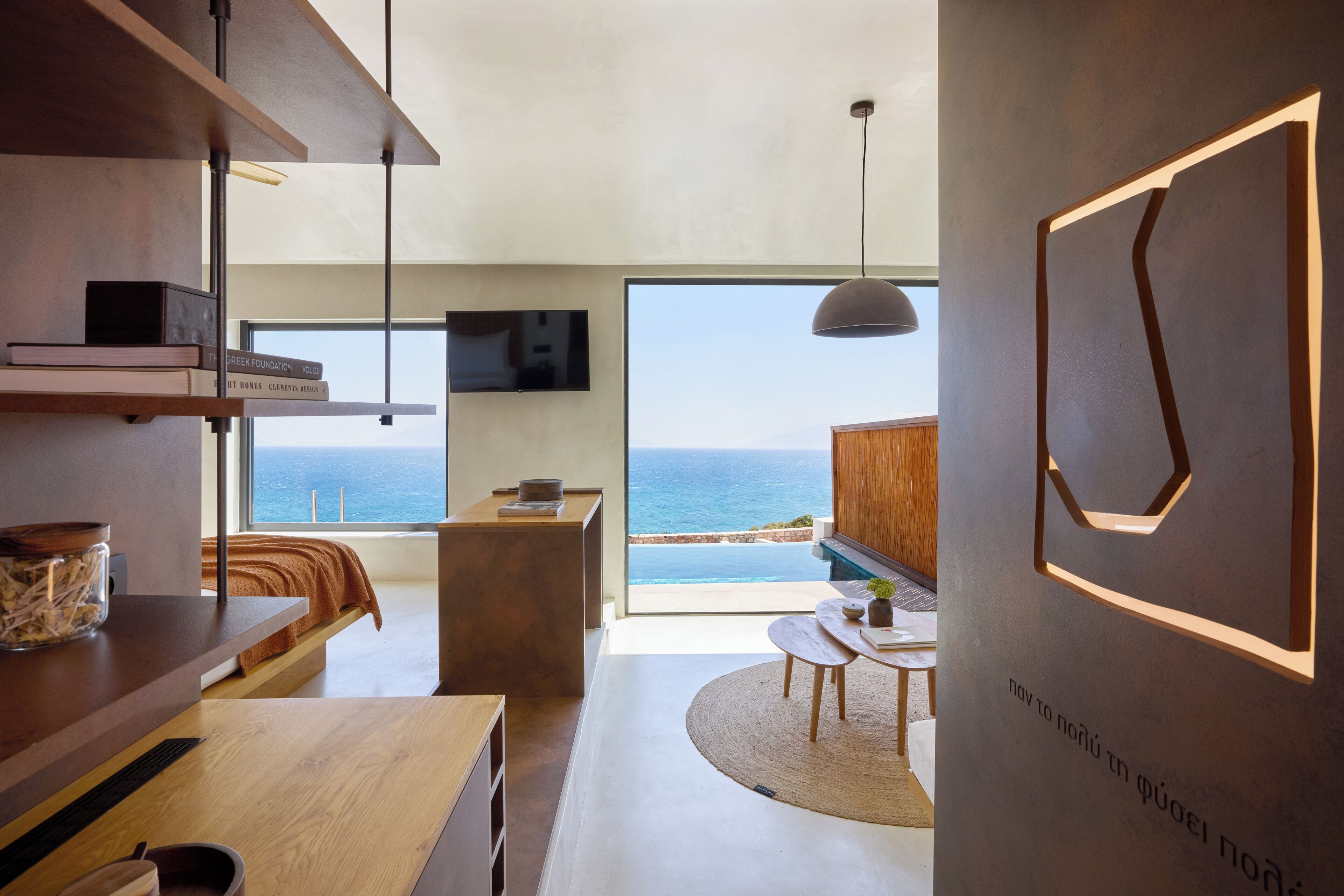 A modern interior with a large window overlooking the sea, a wooden dining table, and a minimalist design.