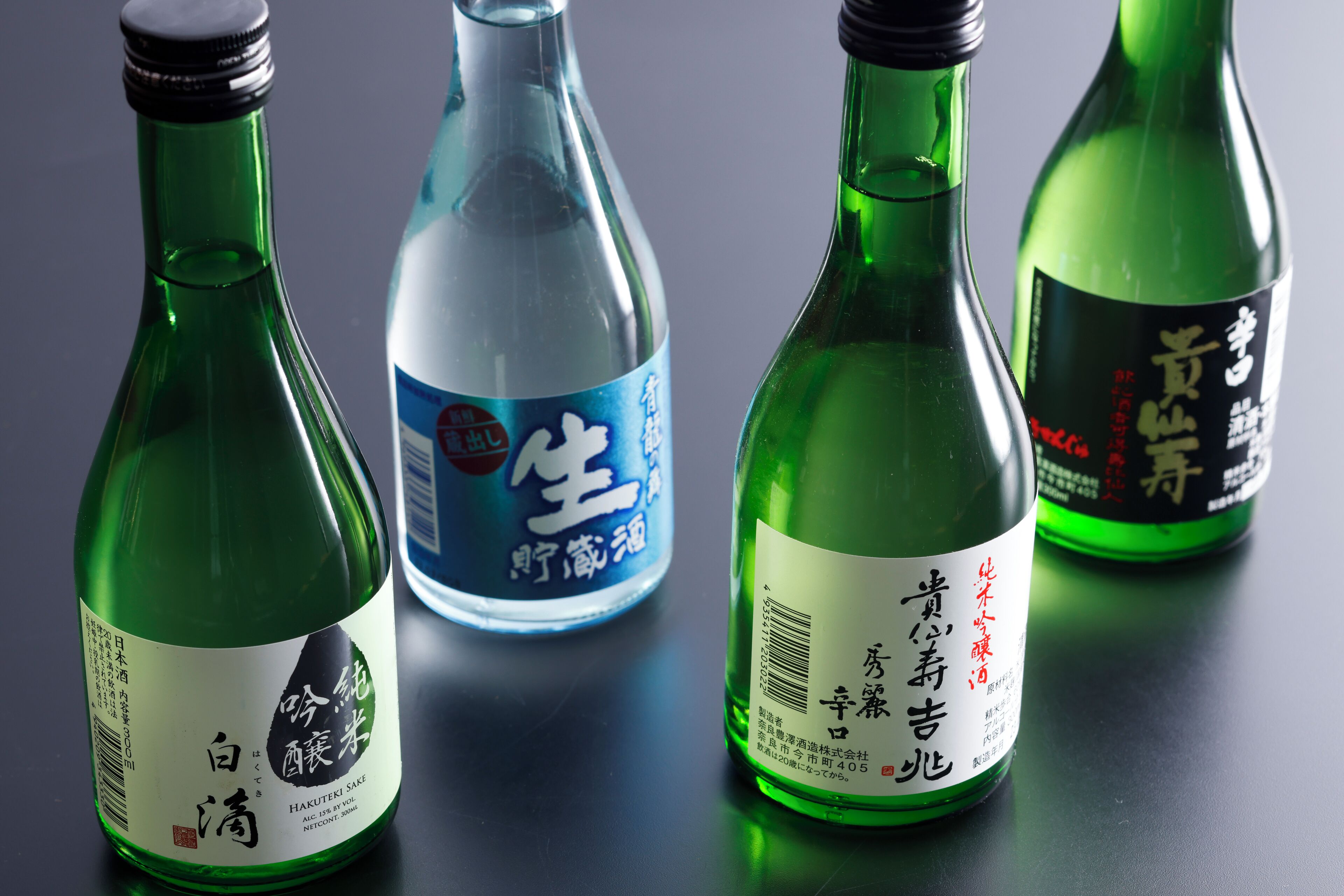 Four bottles of sake on a table.