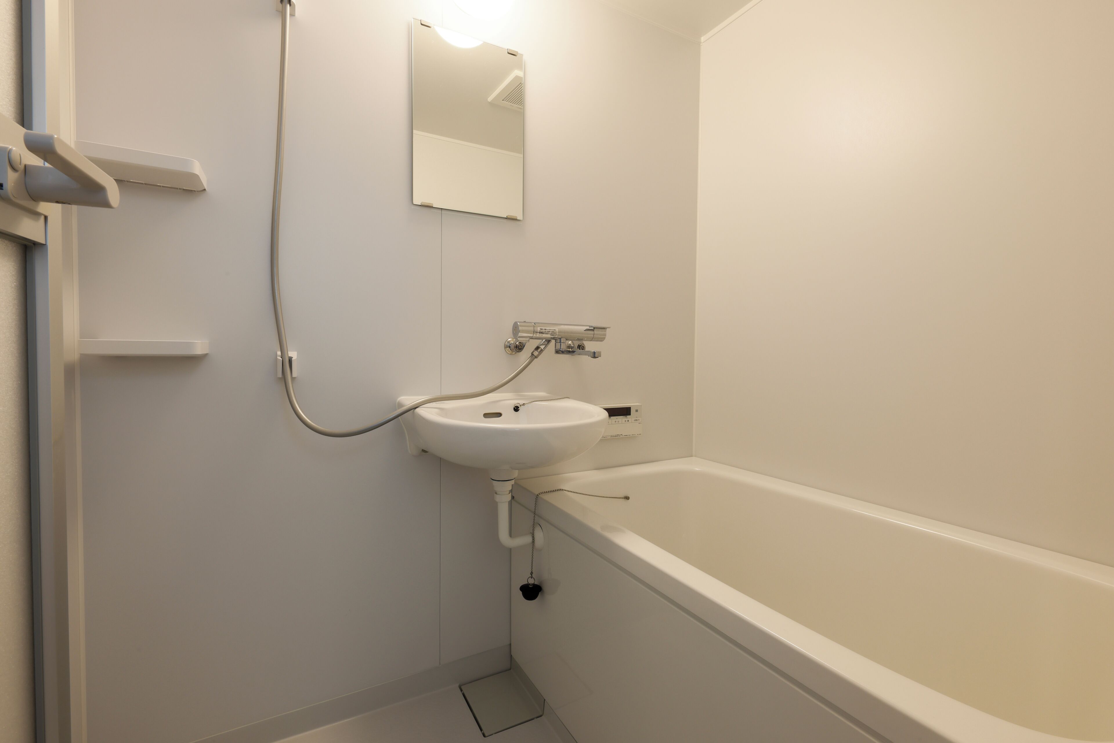 Un baño con un lavamanos blanco, un espejo y una bañera.