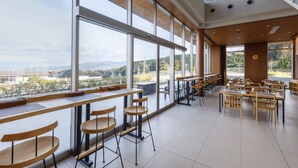 A spacious café with large windows offering a view of the outdoors. - Hotel Nara Sakurai No Sato (Sakurai)