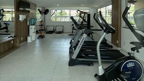 A gym with treadmills, stationary bikes, and a rowing machine.