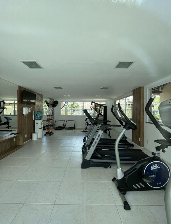 A gym with treadmills, stationary bikes, and a rowing machine.