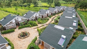 A residential area with multiple houses, each featuring a sloped roof and a small garden area. - Abai Lodges and Spa (Kagio)