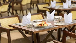 A dining area with tables set for meals, including plates, cutlery, and napkins. - Abai Lodges and Spa (Kagio)
