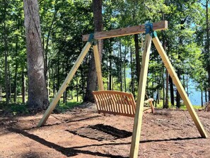 Enjoy a serene forest setting with a charming wooden swing.