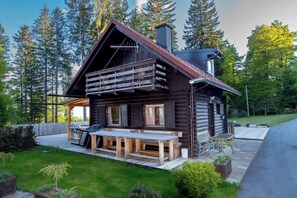 A log cabin with a deck, outdoor seating, and a chimney. - Koča Storzek (Hoce-Slivnica)