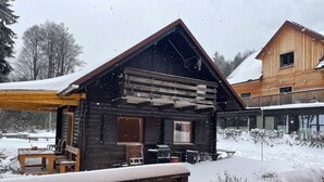 Une cabane en bois dotée d’un patio couvert, d’un coin repas et d’un petit espace salon extérieur.