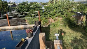 A rooftop pool area with a view of the surrounding neighborhood, including houses and greenery.