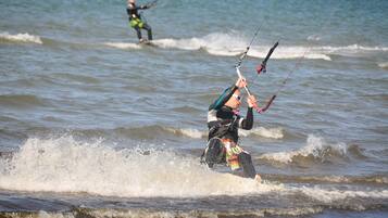Una persona practicando windsurf sobre el agua.