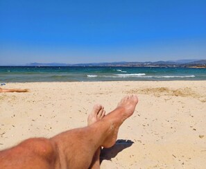 Eine Strandansicht mit blauem Himmel und ruhiger See.