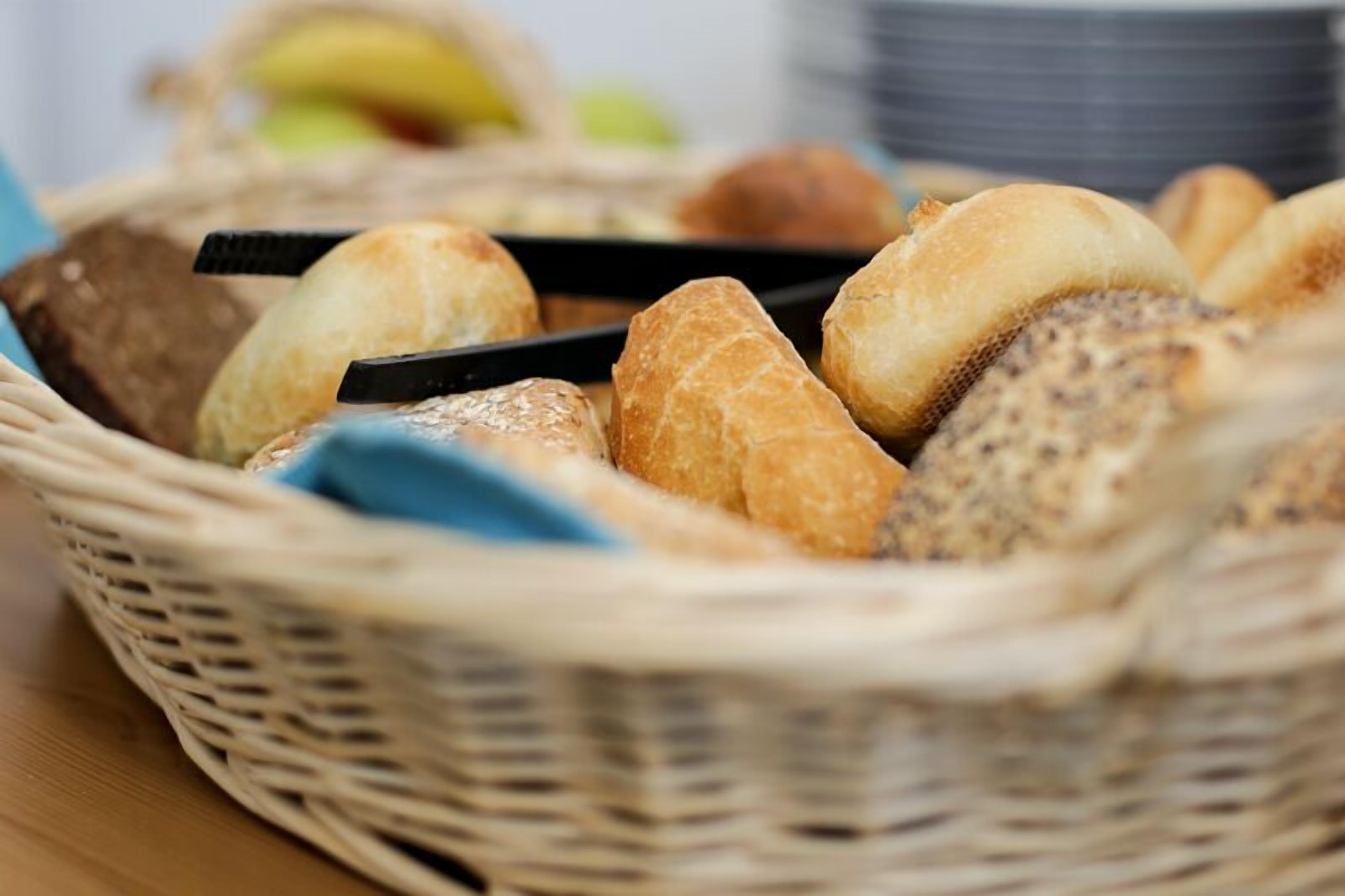 A wicker basket filled with various types of bread.