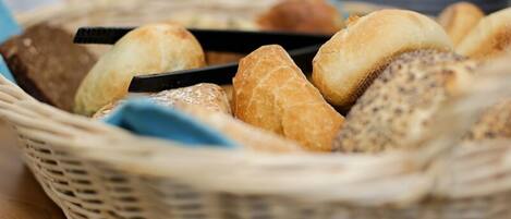 A wicker basket filled with various types of bread.
