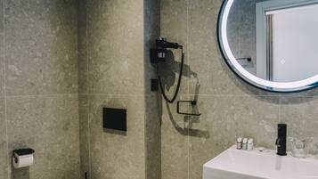 A modern bathroom with a toilet, sink, and mirror.