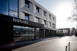 A modern building with a storefront labeled "batuda."