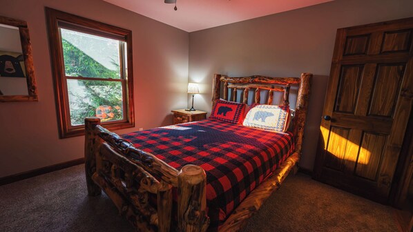 Une chambre à coucher avec un lit, une table de chevet, une lampe, une fenêtre et une porte.