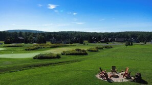 A golf course with a fire pit area and Adirondack chairs. - 6BR Luxury Escape w/ Indoor Pool Boat Dock Avail (Swanton)
