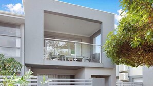 Um edifício moderno de dois andares com uma varanda no andar superior.