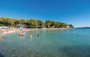 Enjoy a day of swimming and sunbathing on the beach, surrounded by amenities and shade.