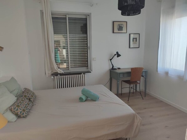 Una camera da letto con un letto, una scrivania e una sedia.