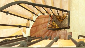 Un escalier avec une main courante en bois et une rambarde en métal.
