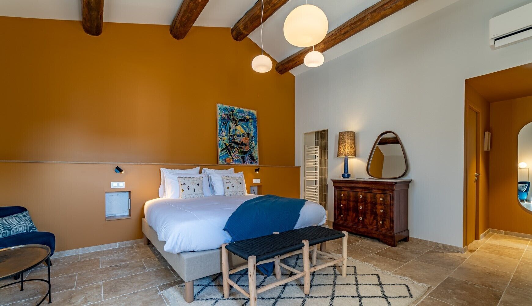Una camera da letto con un letto, un comodino, una lampada e un’opera d’arte appesa al muro.