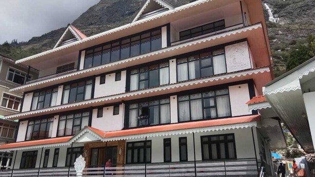 A multi-story building with a traditional architectural style, featuring a balcony on the upper floor and a staircase leading to the entrance.