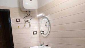 A bathroom with a white toilet, a sink with a mirror above it, and a wall-mounted water heater.
