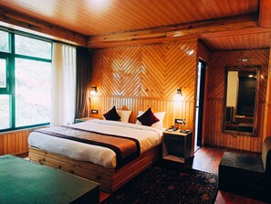 A wooden-paneled bedroom with a large bed, bedside lamps, a mirror, and a view of the outdoors.