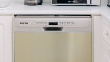 A kitchen with a dishwasher, a coffee maker, and a microwave.