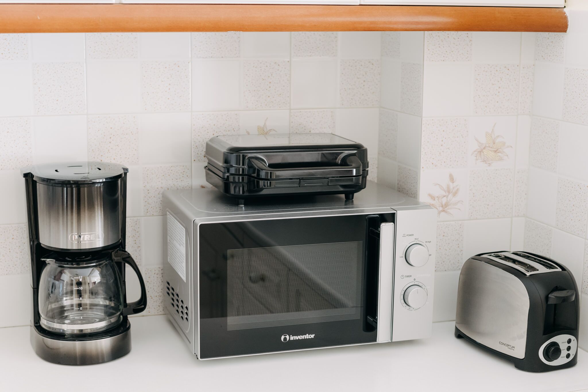 A kitchen with a coffee maker, a toaster, and a microwave.
