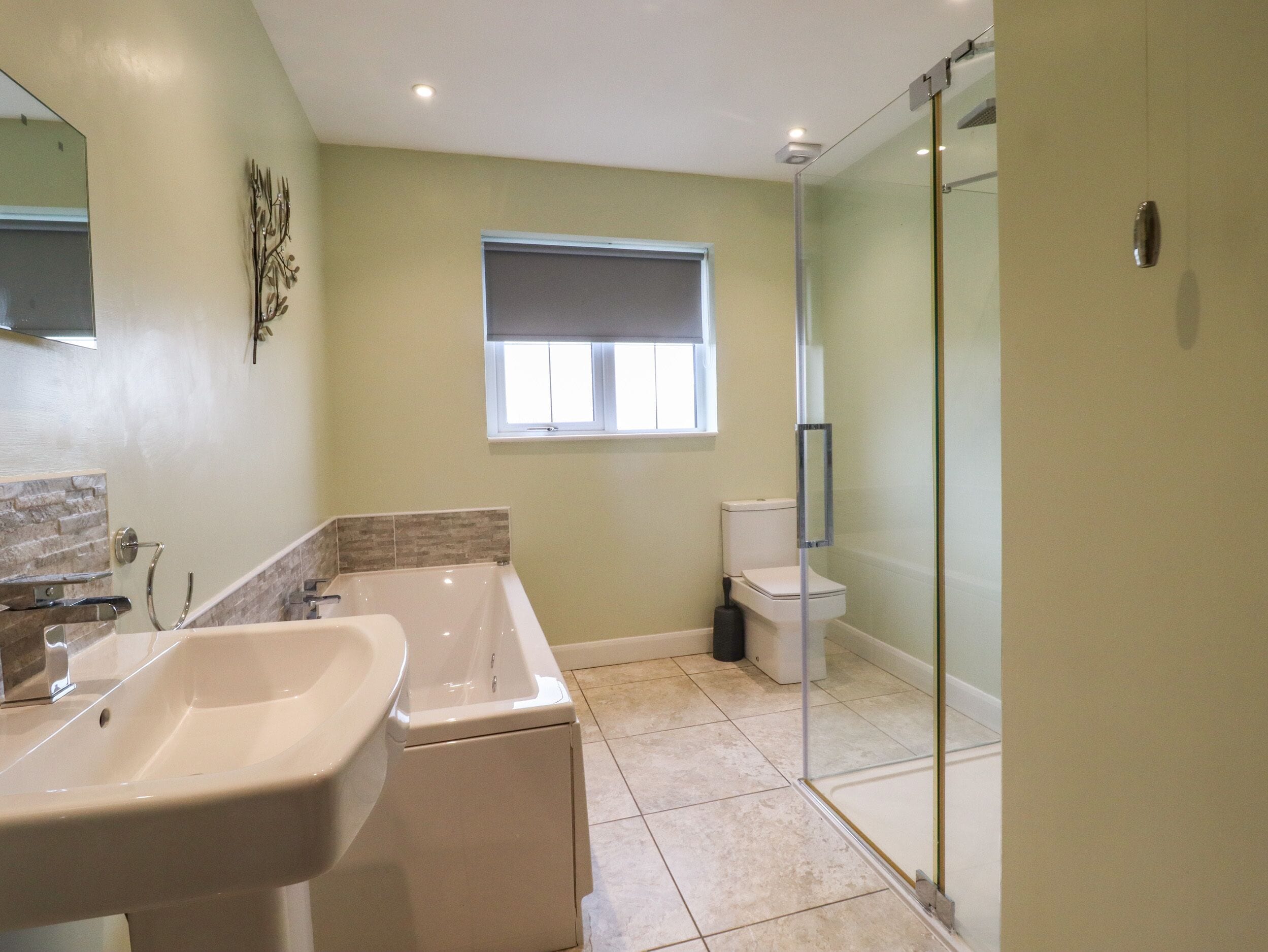 Une salle de bain équipée d’une baignoire, de toilettes et d’une douche à parois de verre.
