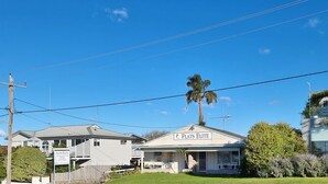 A two-story building with a sign reading "FLATS ELITE." - Close to Beach, Harbour Marina, Country Club, Golf Course, Restaurants, Cafes (Bermagui)