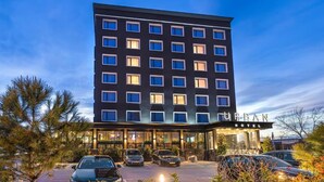 A modern hotel building with a flat facade, multiple windows, and a well-lit entrance area. - Urban Hotel (Plovdiv)