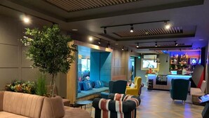 A modern lounge area with sofas, armchairs, and a bar. - Urban Hotel (Plovdiv)