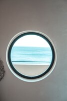 Une fenêtre ronde donnant sur la mer.
