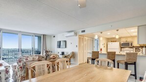 Een modern appartement met een eethoek, keuken en balkon met uitzicht over de stad.