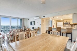 Un apartamento moderno con comedor, cocina y balcón con vista a la ciudad.