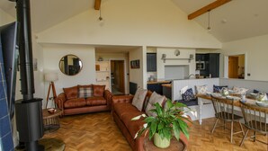 Ein geräumiges Wohnzimmer mit Kamin, Essbereich und Küche.