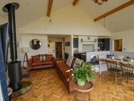 Una sala de estar amplia con chimenea, un comedor y una cocina.