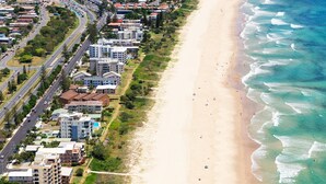 Une zone côtière comprenant une plage, des bâtiments et une route.