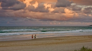 Une plage avec des vagues et un ciel nuageux.