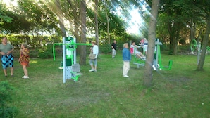 A park with outdoor exercise equipment, including a pull-up bar and a leg press machine. - OSW BALTIC SOPOT (Sopot)