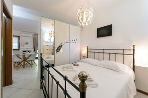 Relax in a spacious room with a large bed, dining area, and mirror.
