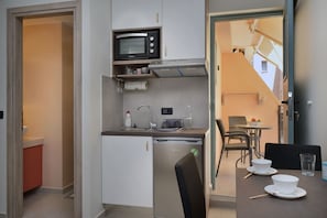 Estudio de diseño | Cocina básica privada | Frigorífico pequeño, horno, placa de cocina y máquina de café espresso